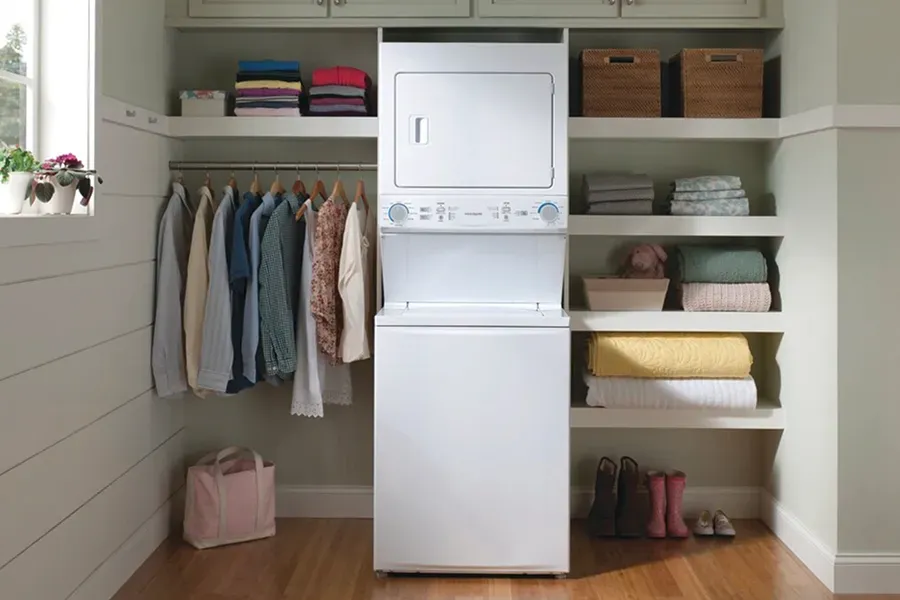 Frigidaire FLCG7522AW white stacked laundry center (washer/gas dryer) installed in a closet to maximize vertical storage space in a tight area.